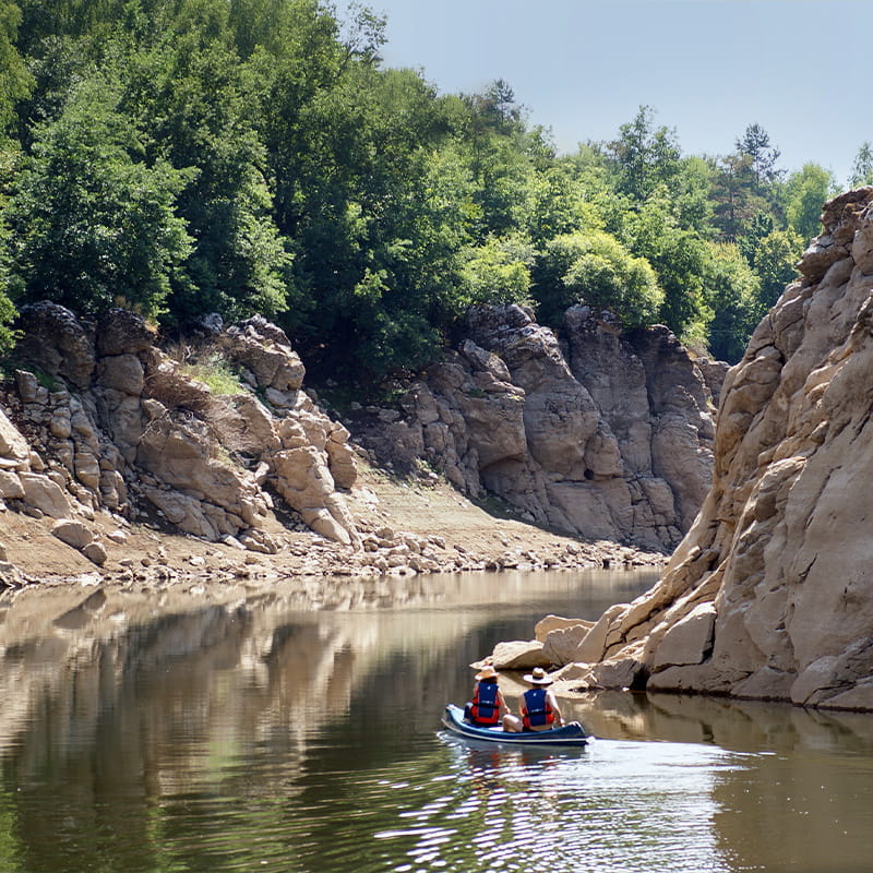 Location Summer Water & Landscape people in canoe rowing through canyon of Lika river on a clear summer day