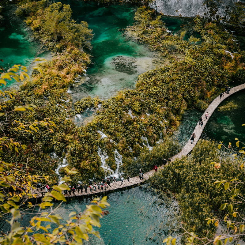 Plitvice Lakes Location drone shot of people walking on a wooden path in Plitvice national park