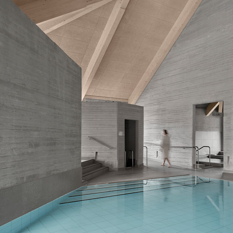 VPR Wellness Architecture Woman walking through minimal wellness area with gray stone walls and floors